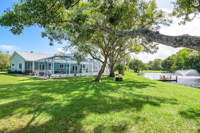 view of yard featuring a lanai, a pool, and a water view