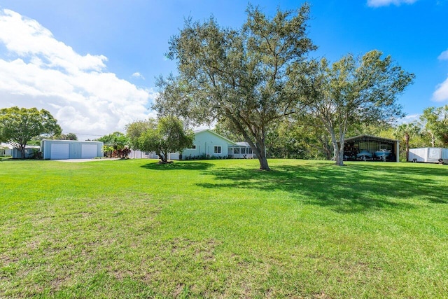 view of yard featuring a garage and an outbuilding