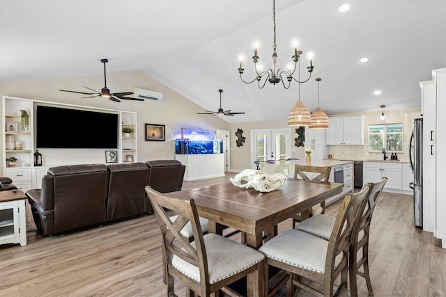 dining area with light hardwood / wood-style flooring, a healthy amount of sunlight, sink, and vaulted ceiling