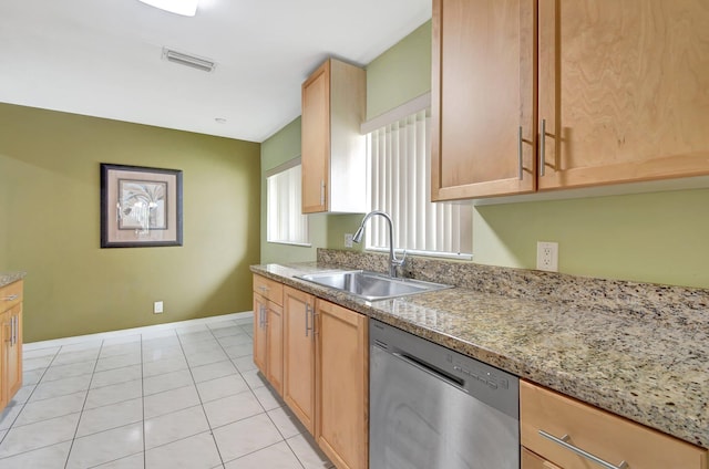 kitchen featuring light tile patterned floors, light brown cabinetry, light stone countertops, sink, and stainless steel dishwasher