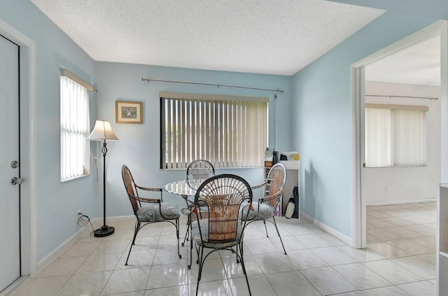 tiled dining area with a textured ceiling