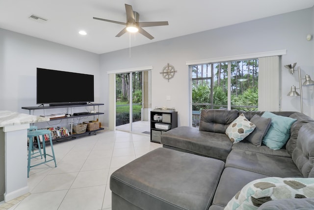 living room with ceiling fan, light tile patterned flooring, and a wealth of natural light