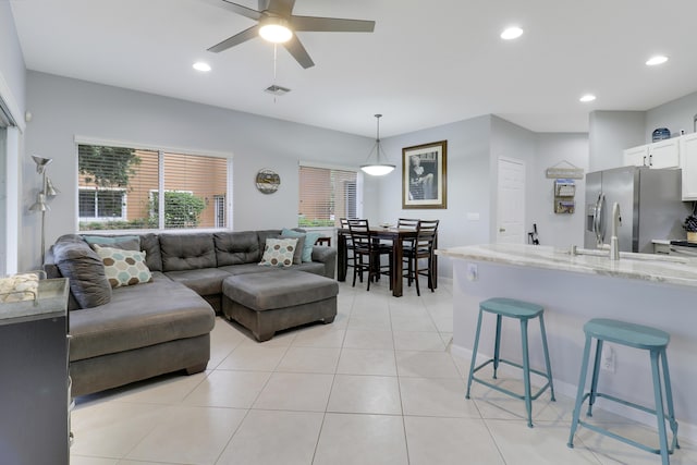 tiled living room featuring ceiling fan