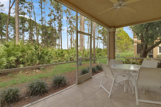 unfurnished sunroom featuring ceiling fan