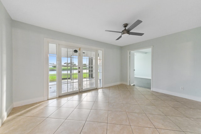 tiled spare room featuring french doors and ceiling fan