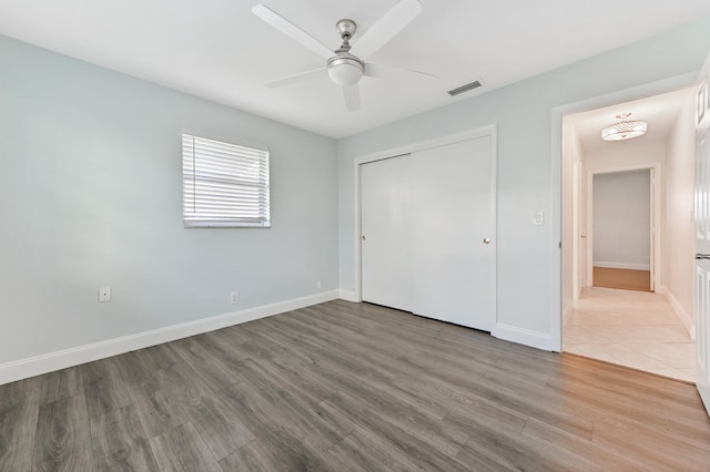 unfurnished bedroom with a closet, ceiling fan, and hardwood / wood-style flooring