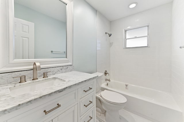 full bathroom featuring vanity, tiled shower / bath combo, and toilet