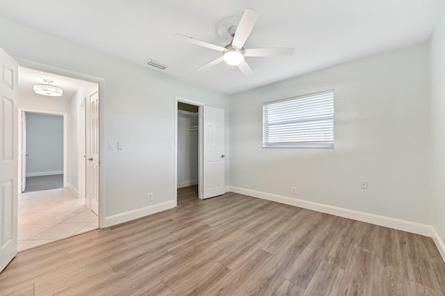 unfurnished bedroom featuring a closet, light wood-type flooring, and ceiling fan