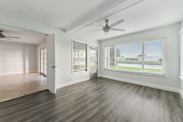 unfurnished room with beam ceiling, ceiling fan, and dark hardwood / wood-style flooring