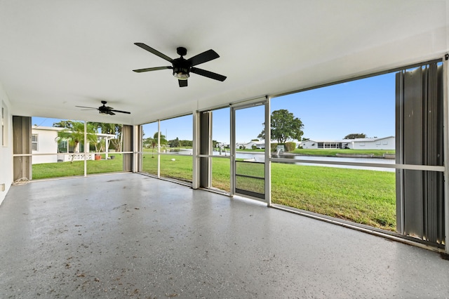 unfurnished sunroom featuring a water view and ceiling fan