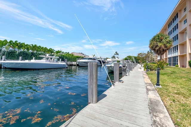 dock area with a water view and a lawn