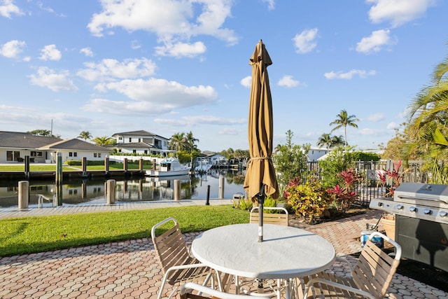 view of patio featuring a water view, a dock, and area for grilling