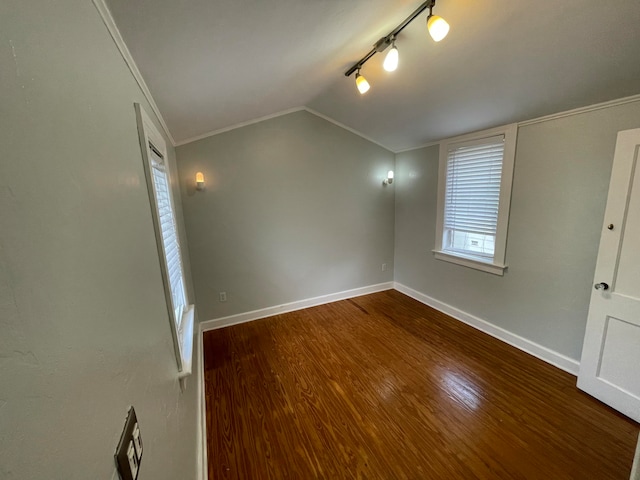 empty room with crown molding, hardwood / wood-style flooring, and lofted ceiling