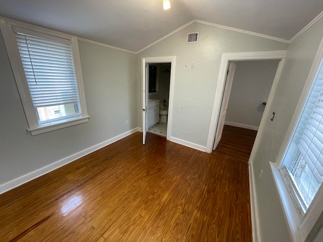 unfurnished bedroom with connected bathroom, crown molding, vaulted ceiling, and hardwood / wood-style flooring