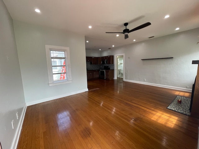 unfurnished living room featuring ceiling fan and dark hardwood / wood-style flooring