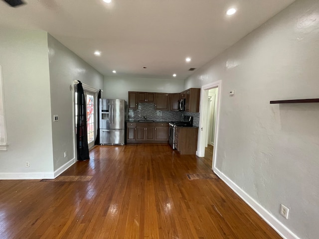 kitchen featuring stainless steel appliances, decorative backsplash, sink, and dark hardwood / wood-style floors