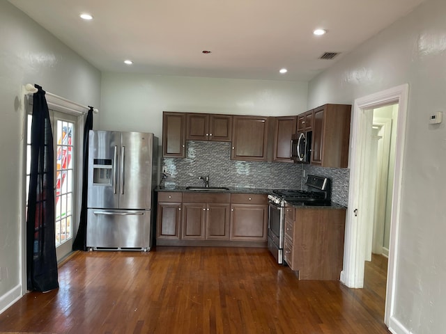 kitchen featuring backsplash, sink, stainless steel appliances, and dark hardwood / wood-style floors