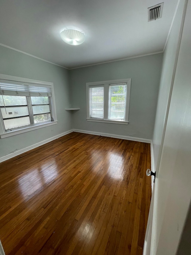 unfurnished room with wood-type flooring and ornamental molding