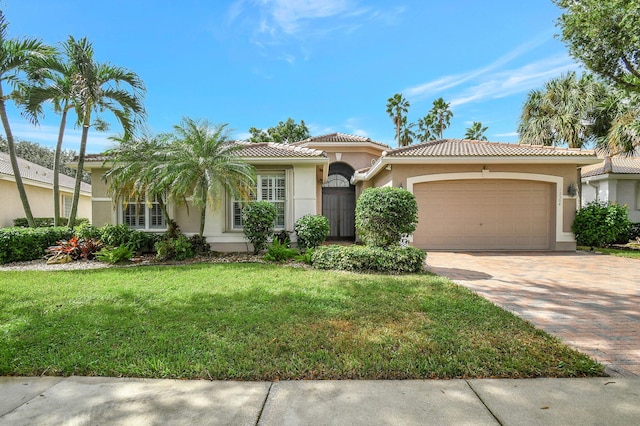 mediterranean / spanish home with a garage and a front lawn