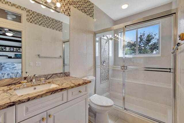 bathroom featuring a shower with door, vanity, toilet, and tile patterned flooring