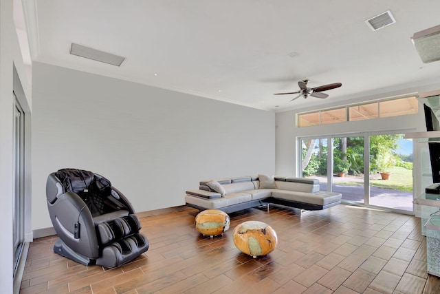 living room featuring light hardwood / wood-style floors, crown molding, and ceiling fan