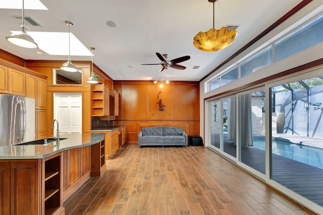 bedroom with hardwood / wood-style floors, sink, crown molding, and stainless steel refrigerator