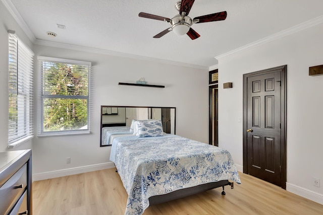 bedroom featuring crown molding, multiple windows, light hardwood / wood-style floors, and ceiling fan