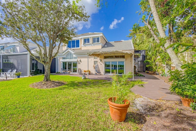 back of property with a yard and a patio