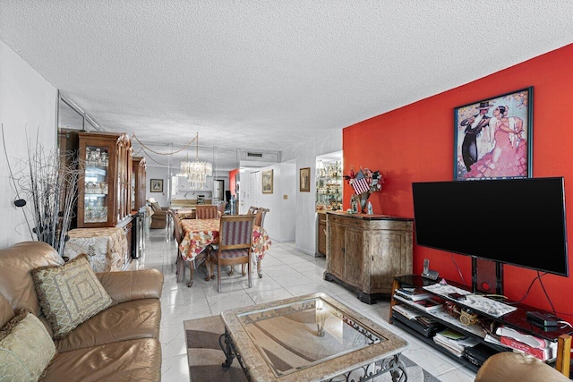 living room featuring a textured ceiling, a notable chandelier, and light tile patterned floors