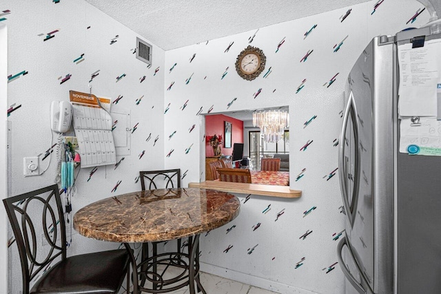 dining space featuring a textured ceiling and an inviting chandelier