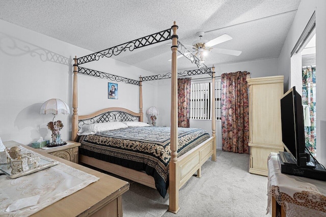 carpeted bedroom featuring ceiling fan and a textured ceiling