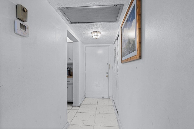 hallway with a textured ceiling