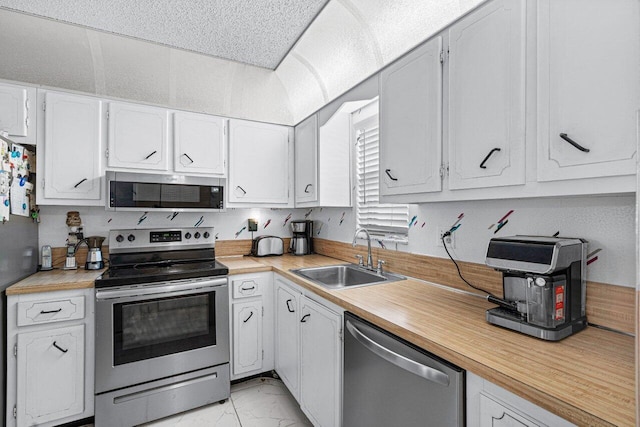 kitchen featuring stainless steel appliances, white cabinetry, and sink