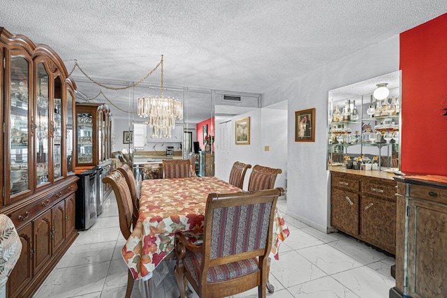 dining area featuring an inviting chandelier, a wealth of natural light, and a textured ceiling