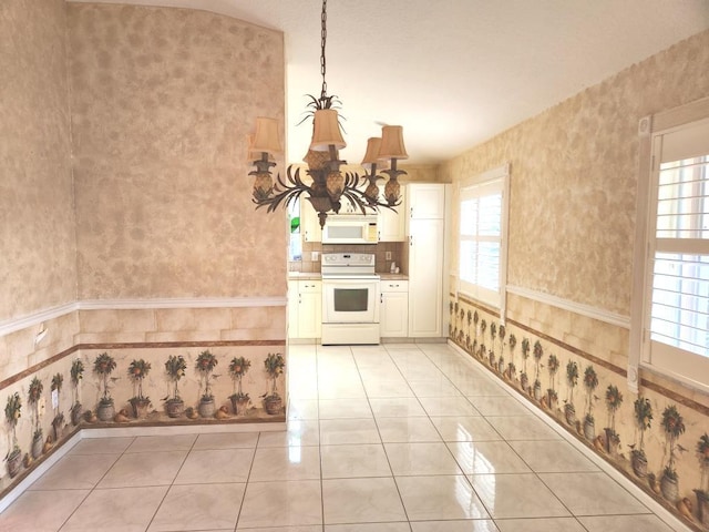 kitchen featuring an inviting chandelier, hanging light fixtures, white appliances, and light tile patterned floors