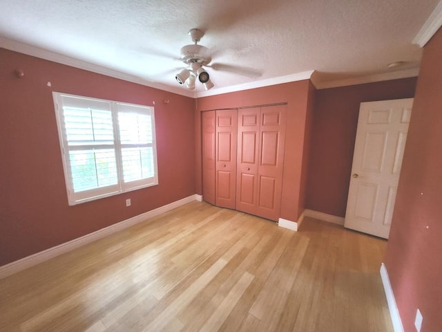 unfurnished bedroom with a closet, light hardwood / wood-style floors, ornamental molding, and ceiling fan