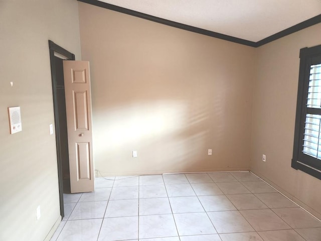 spare room with ornamental molding and light tile patterned flooring