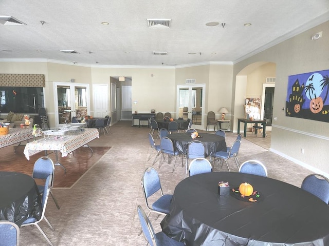 carpeted dining space featuring ornamental molding