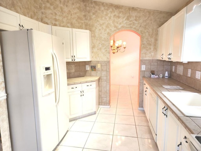 kitchen featuring tile countertops, white cabinetry, light tile patterned floors, and white appliances