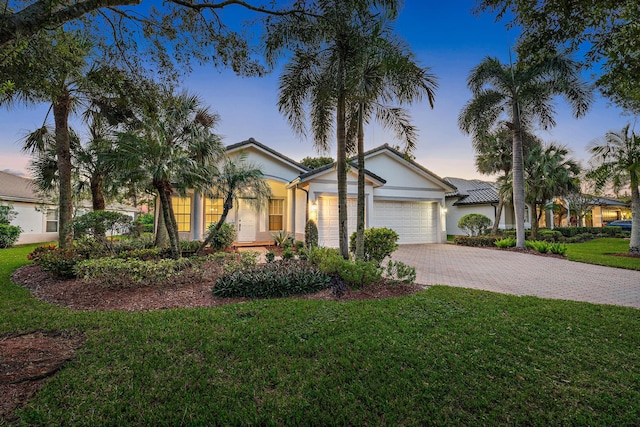 view of front of home with a garage and a lawn