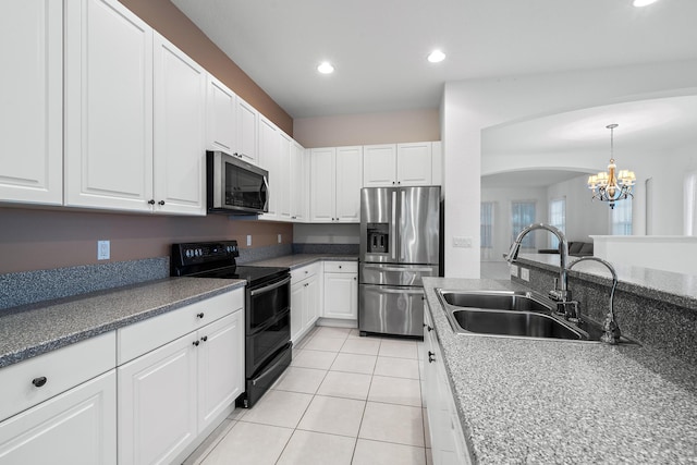 kitchen with hanging light fixtures, appliances with stainless steel finishes, an inviting chandelier, white cabinetry, and sink