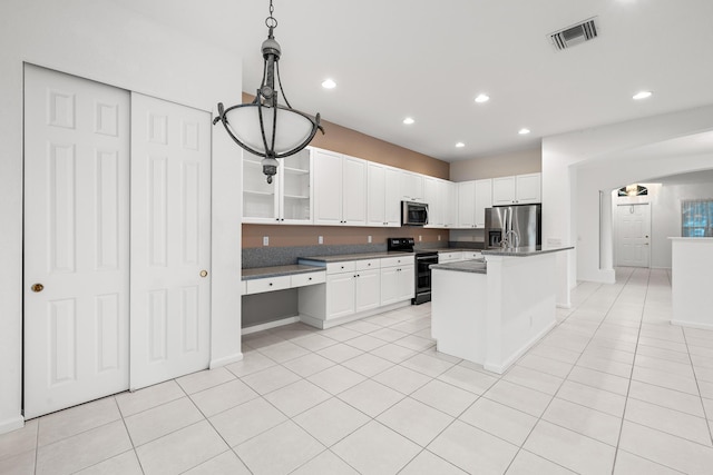 kitchen with appliances with stainless steel finishes, white cabinets, a center island, and hanging light fixtures