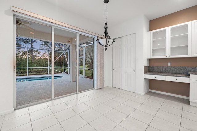 unfurnished dining area with light carpet and ceiling fan