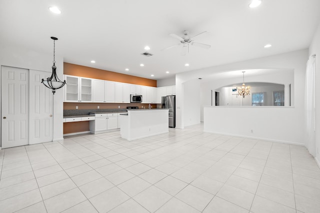 kitchen featuring appliances with stainless steel finishes, ceiling fan with notable chandelier, a center island, hanging light fixtures, and white cabinets