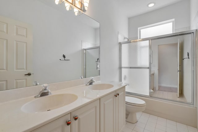 full bathroom with vanity, tile patterned floors, combined bath / shower with glass door, and toilet