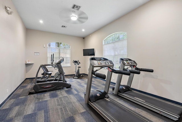 exercise room featuring ceiling fan and dark carpet