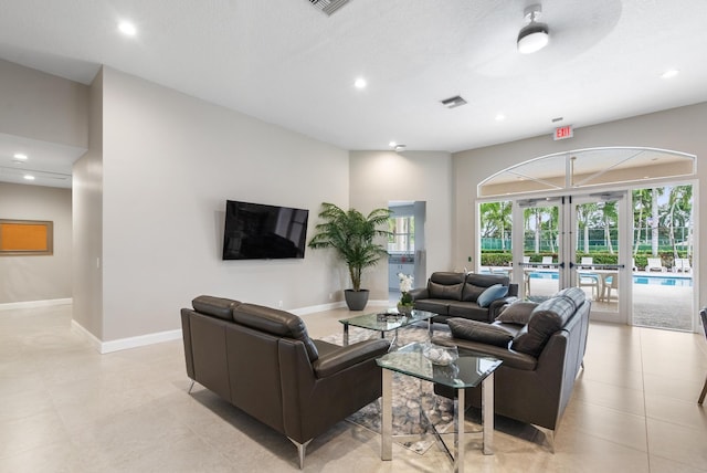 living room featuring ceiling fan and french doors