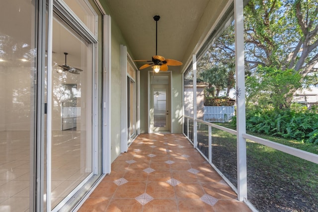 unfurnished sunroom featuring ceiling fan