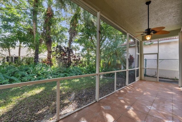 unfurnished sunroom featuring ceiling fan