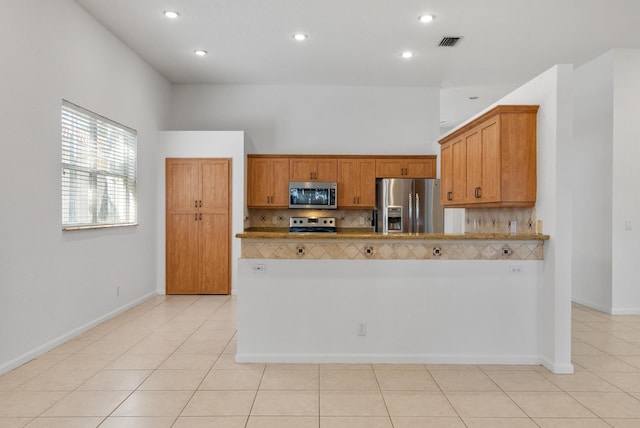 kitchen featuring stainless steel appliances, light tile patterned floors, and decorative backsplash